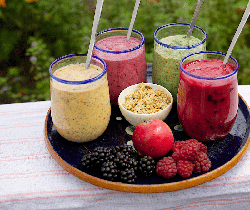 4 colorful smoothies and berries