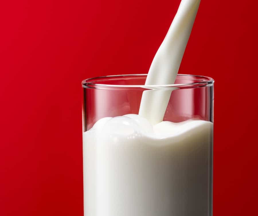white milk in front of a red background. dairy milk linked to prostate cancer