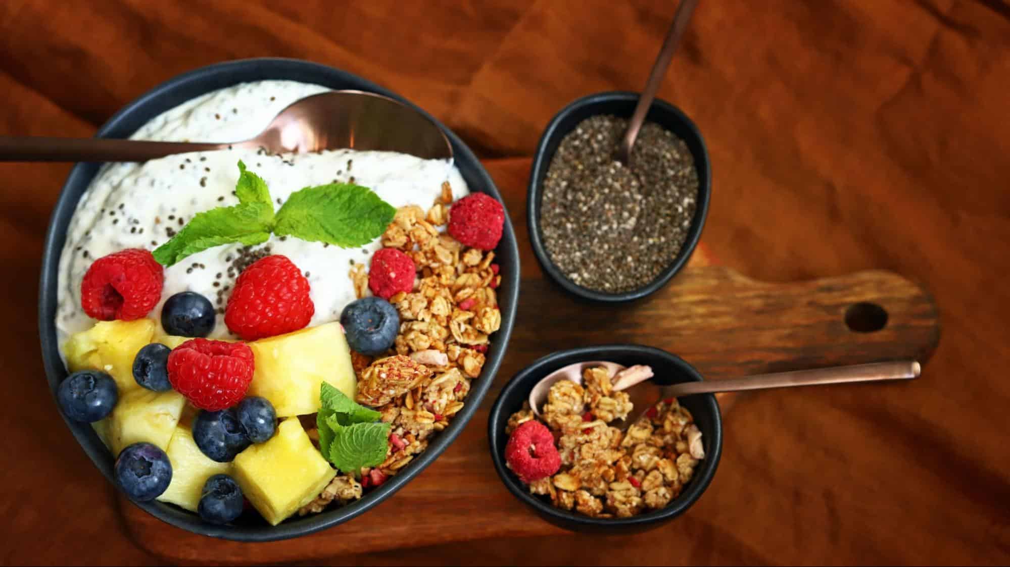 Vegan yogurt bowl with chia seeds, granola, and mixed berries, and pineapple